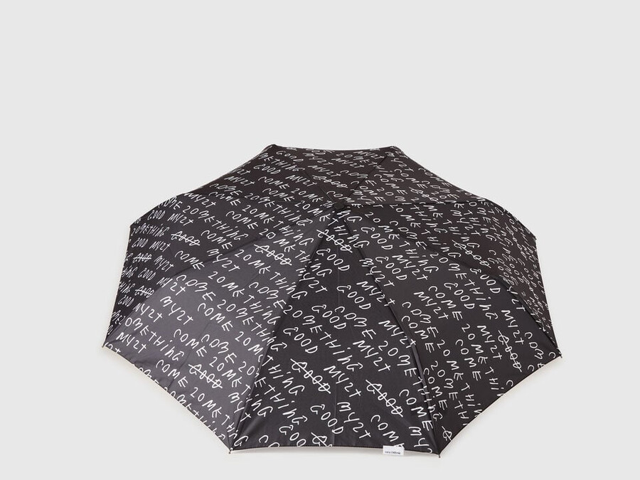 schwarzer regenschirm mit coco capitán-schriftzug