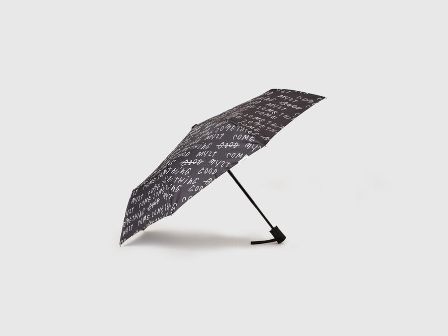 schwarzer regenschirm mit coco capitán-schriftzug